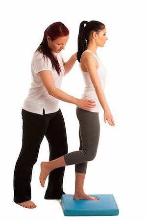 Physiotherapy - therapist doing excercises for improving coordination and stability with a patient to recover after injury